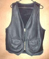  The black motorcycle vest has a large brass (YKK #10) zipper and two patch pockets with flaps. It also has a 3" back/bottom draft flap extension. Clicking on the link will bring you to a page with a picture of the vests' back.  