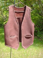  This brown moccasin cowhide leather vest has no front lapels or yokes. It does have a back yoke that goes straight across (not pointed) and slit hip pockets (without flaps). 